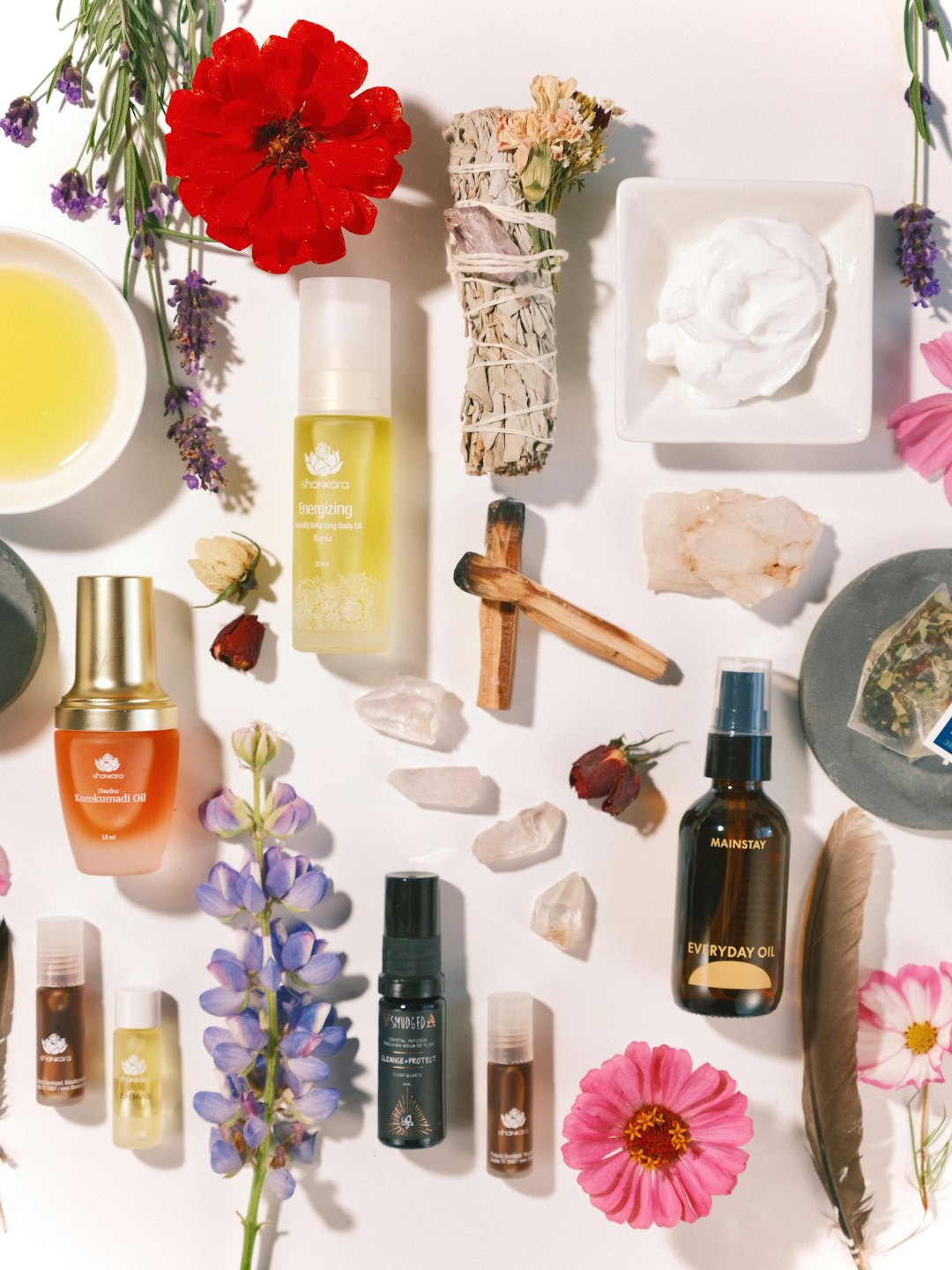 Přírodní wellness produkty a botanika uspořádané na bílém povrchu.